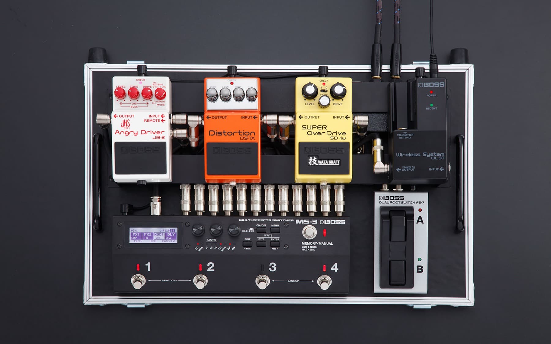 Top-down view of a pedalboard: a JHS-Boss JB-2 Angry Driver, a DS-1X Distortion and an SD-1W Waza Craft Super Overdrive patched into a Boss MS-3 switcher, with a WL-50 wireless receiver and an FS-7 dual footswitch on the right